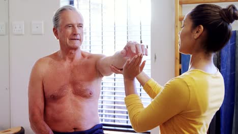 Physiotherapist-giving-hand-massage-to-senior-man-4k