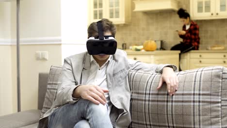 Gut-aussehender-Mann-nutzt-virtual-Reality-Brille-zu-Hause