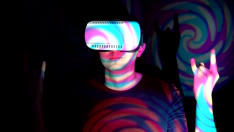 Young-man-in-virtual-reality-glasses-doing-horns-sign-with-his-fingers