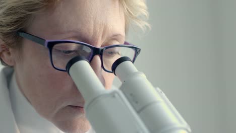 Female-scientist-looking-through-microscope