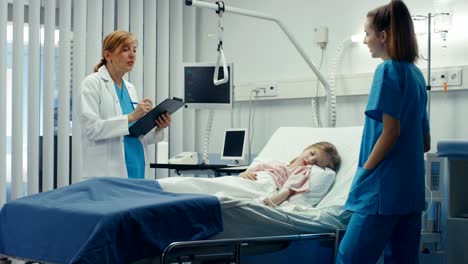 Kleine-Mädchen-liegt-auf-einem-Bett-im-Krankenhaus,-krank,-freundlicher-Arzt-schreibt-Krankenakte-/-Daten-in-Zwischenablage,-Vorträge-mit-Krankenschwester.-Niedliches-erkrankte-Kind-ist-genommen-Care-Of-in-der-modernen-Kinderheilkunde-/-Kinderabteilung.