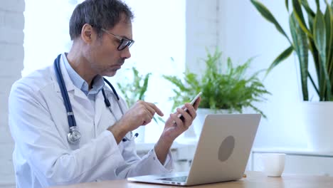 Doctor-Browsing-Internet-on-Smartphone-in-Clinic