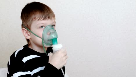 Usando-el-nebulizador-y-el-inhalador-para-el-tratamiento.-Niño-de-inhalar-a-través-de-mascarilla-inhalador.-Vista-lateral.