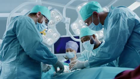 Diverse-Team-of-Professional-surgeon,--Assistants-and-Nurses-Performing-Invasive-Surgery-on-a-Patient-in-the-Hospital-Operating-Room.-Surgeons-Talk-and-Use-Instruments.-Real-Modern-Hospital-with-Authentic-Equipment.