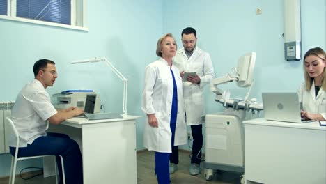 Young-man-with-tablet-having-look-around-medical-office