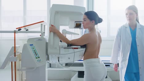 Im-Krankenhaus,-Seite-Ansicht-Schuss-oben-ohne-weibliche-Patienten-unterziehen-Mammographie-Screening-Verfahren.-Gesunde-junge-Frau-hat-Krebs-vorbeugende-Mammographie-Scan.-Moderne-Krankenhaus-mit-Hightech-Maschinen.