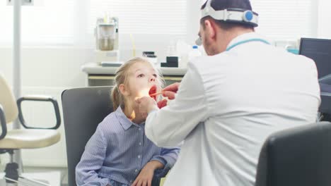 Friendly-Doctor-Checks-up-Little-Girl's-Sore-Throat,-Curing-Flu.-Modern-Medical-Health-Care,-Friendly-Pediatrician-and-Bright-Office.