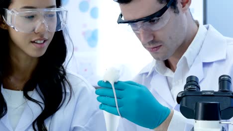 Scientist-holding-mice-in-hand-and-Talking-together.-Scientist-researching-for-mice-at-lab.-4K-Resolution.