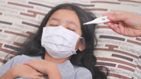 Little-Asian-girl-sick-at-home-and-coughing.-The-mother-measured-the-daughter's-fever-with-mercury.