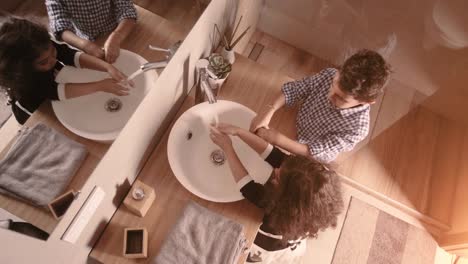 Closeup-portrait-of-kids-toddler-boy-girl-in-bathroom-toilet-washing-hands-at-coronavirus-pandemic-time.