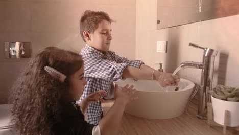 Closeup-portrait-of-kids-toddler-boy-girl-in-bathroom-toilet-washing-hands-at-coronavirus-pandemic-time.