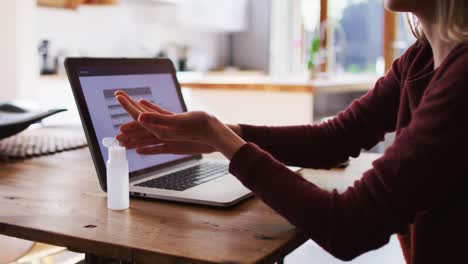 Woman-sanitizing-her-hands-at-home