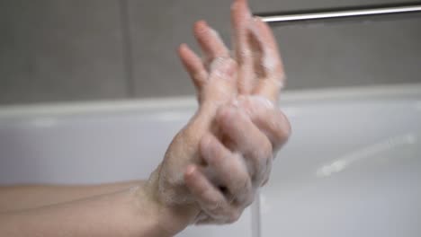 woman-washing-her-hands-properly-with-plenty-of-soap-in-her-home-sink-without-wasting-water