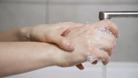 Frau-waschen-ihre-Hände-richtig-mit-viel-Seife-in-ihrem-Haus-Waschbecken,-ohne-Wasser-zu-verschwenden