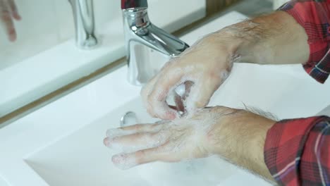 Wash-hands-with-soap,under-the-tap-with-water,close-up,male-hands-wash-bacteria,dirt,cleanliness,and-body-hygiene