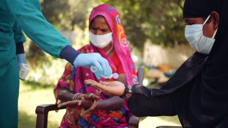 Ärzte-im-Freien-mit-einer-Seniorin-im-ländlichen-Indien