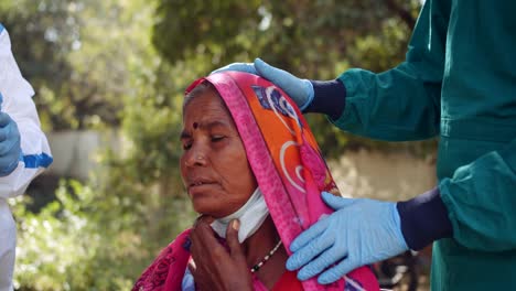 Ärzte-im-Freien-mit-einer-Seniorin-im-ländlichen-Indien