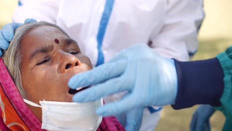 Medical-staff-doctors-outdoors-with-a-senior-female-in-rural-India