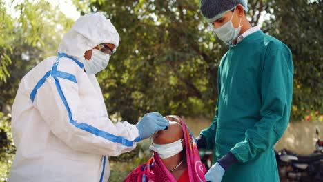 Médicos-médicos-al-aire-libre-con-una-mujer-de-la-tercera-edad-en-las-zonas-rurales-de-la-India