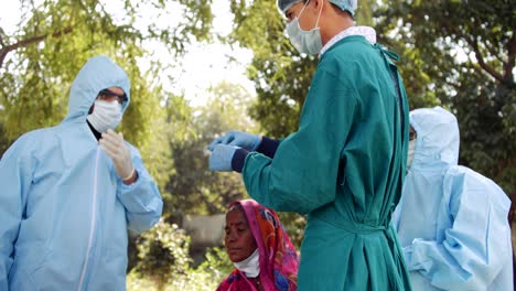 Medical-staff-doctors-outdoors-with-a-senior-female-in-rural-India