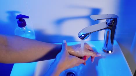 Hygiene.-Cleaning-Hands.-Washing-hands-with-soap.-Young-woman-washing-hands-with-soap-over-sink-in-bathroom,-closeup.-Covid-19.-Coronavirus.