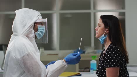 Medical-worker-in-protective-clothing-taking-swab-test-from-female-patient