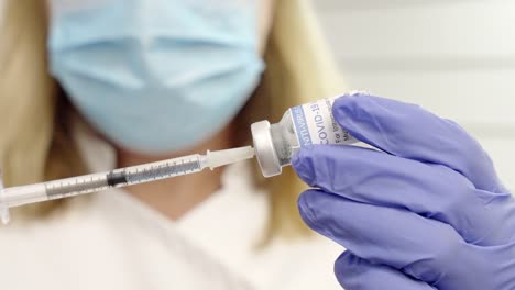 close-shot-of-female-with-a-coronavirus-vial-and-syringe