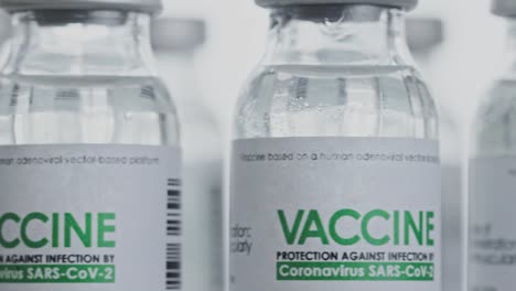 Looped.-Flasks-of-vaccine-for-COVID-19-coronavirus-cure-are-slowly-rotated-in-research-lab.-Vaccination,-injection,-clinical-trial-during-pandemic.-Bottles,-vials-are-spinning-clockwise.-Closeup-macro