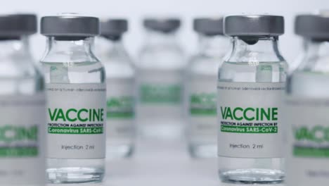 Bottles-of-vaccine-for-coronavirus-COVID-19-cure-are-in-research-lab-before-injection.-Vaccination,-clinical-trial-during-pandemic.-Flacons,-vials.-Wide-macro-slider-dolly-out-shot.-SARS-Cov-2.-No-one