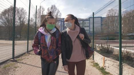 Mother-and-daughter-a-teenager-walking-down-the-street-in-protective-masks.