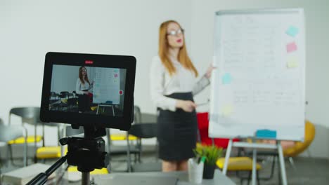 Mujer-sonriente-hablando-con-los-estudiantes-a-través-de-videoconferencia-en-tablet-PC.-Joven-maestra-que-tiene-clase-en-línea.-Educación-remota,-distanciamiento-social,-prevención-de-cuarentena.