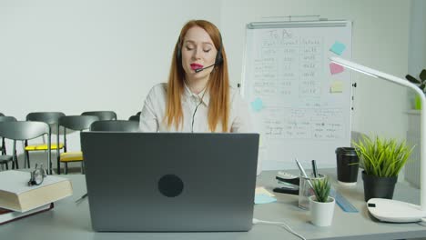 Una-mujer-con-auriculares-está-enseñando-una-clase-en-línea.-Estudio-distante,-educación-remota,-lección-en-línea-durante-el-encierro.