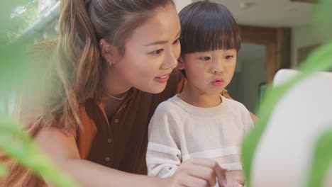 Asiatische-Mutter-hilft-zu-Hause-Schulbildung-Sohn-arbeiten-am-Tisch-in-Küche-auf-Laptop