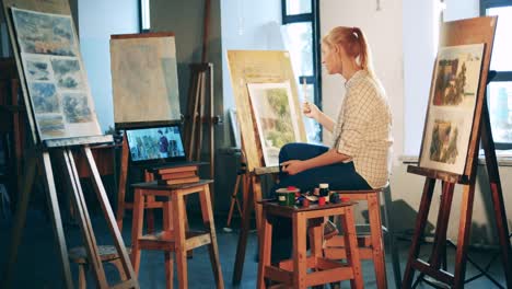 Una-señora-está-estudiando-pintura-en-línea-en-el-estudio-de-arte