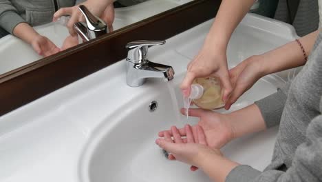 Mom-assisting-her-kid-while-washing-hands