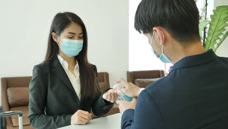 Hotel-receptionists-using-alcohol-gel-wash-hands-with-customers