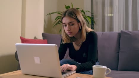 Turkish-young-woman-working-or-studying-at-home-with-a-computer-on-the-table-with-a-coffee-cup