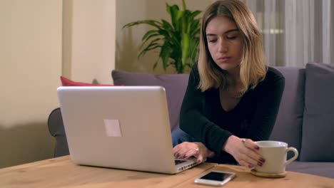 Turkish-young-woman-working-or-studying-at-home-with-a-computer-on-the-table-with-a-coffee-cup