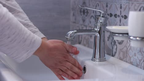 Mann,-der-Hände-im-Badezimmer-wäscht