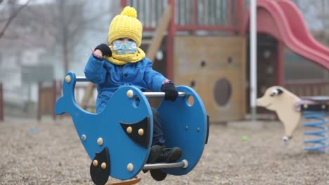 Little-toddler-child,-boy,-wearing-medical-mask-while-on-little-walk-during-the-Covid-lockdown