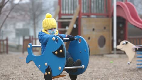 Little-toddler-child,-boy,-wearing-medical-mask-while-on-little-walk-during-the-Covid-lockdown