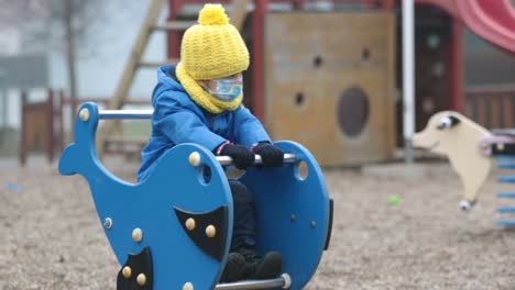 Little-toddler-child,-boy,-wearing-medical-mask-while-on-little-walk-during-the-Covid-lockdown