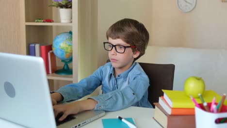 Child-Boy-Kid-schoolboy-in-glasses-using-tablet-laptop-computer-for-school-homework,-studying-at-home