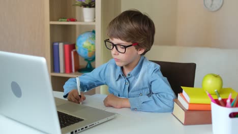 Kind-Junge-Kind-Schuljunge-in-Gläsern-mit-Tablet-Laptop-Computer-für-Schulhausaufgaben,-Lernen-zu-Hause