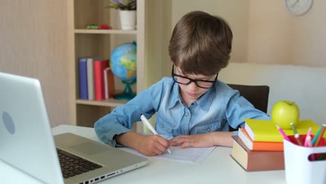 Kind-Junge-Kind-Schuljunge-in-Gläsern-mit-Tablet-Laptop-Computer-für-Schulhausaufgaben,-Lernen-zu-Hause