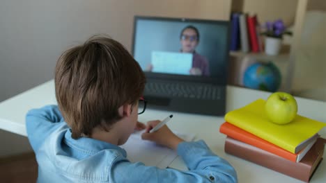 Pequeño-colegial-con-profesor-usando-tableta-computadora-portátil-para-la-tarea-escolar,-estudiando-en-casa