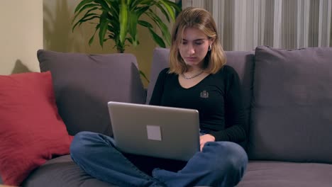 Young-Turkish-woman-using-a-laptop-computer-while-sitting-on-the-sofa.