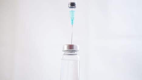 Close-up-of-a-Syringe-with-a-Needle-Drawing-a-Medicine-from-a-Glass-Vial