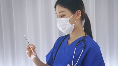 Close-up-of-female-Asian-doctor-holding-a-vaccine-injection-needle-ready-for-vaccination.-Young-medical-lab-technicia-at-work