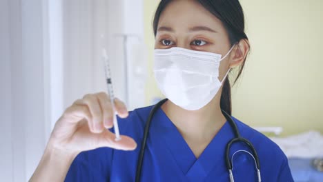 Close-up-of-female-Asian-doctor-holding-a-vaccine-injection-needle-ready-for-vaccination.-Young-medical-lab-technicia-at-work